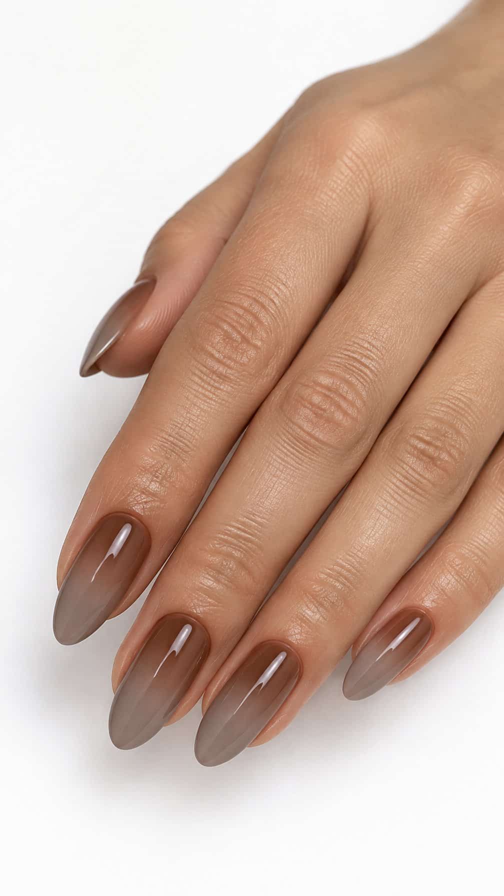 Almond-shaped nails painted in a smooth hazelnut and mushroom brown ombre