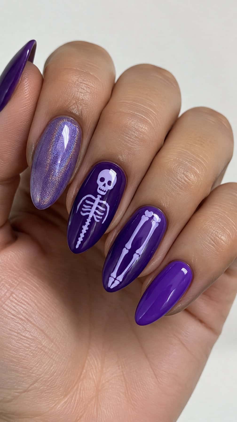 Glossy purple gel nails featuring simple pale skeleton designs on several nails