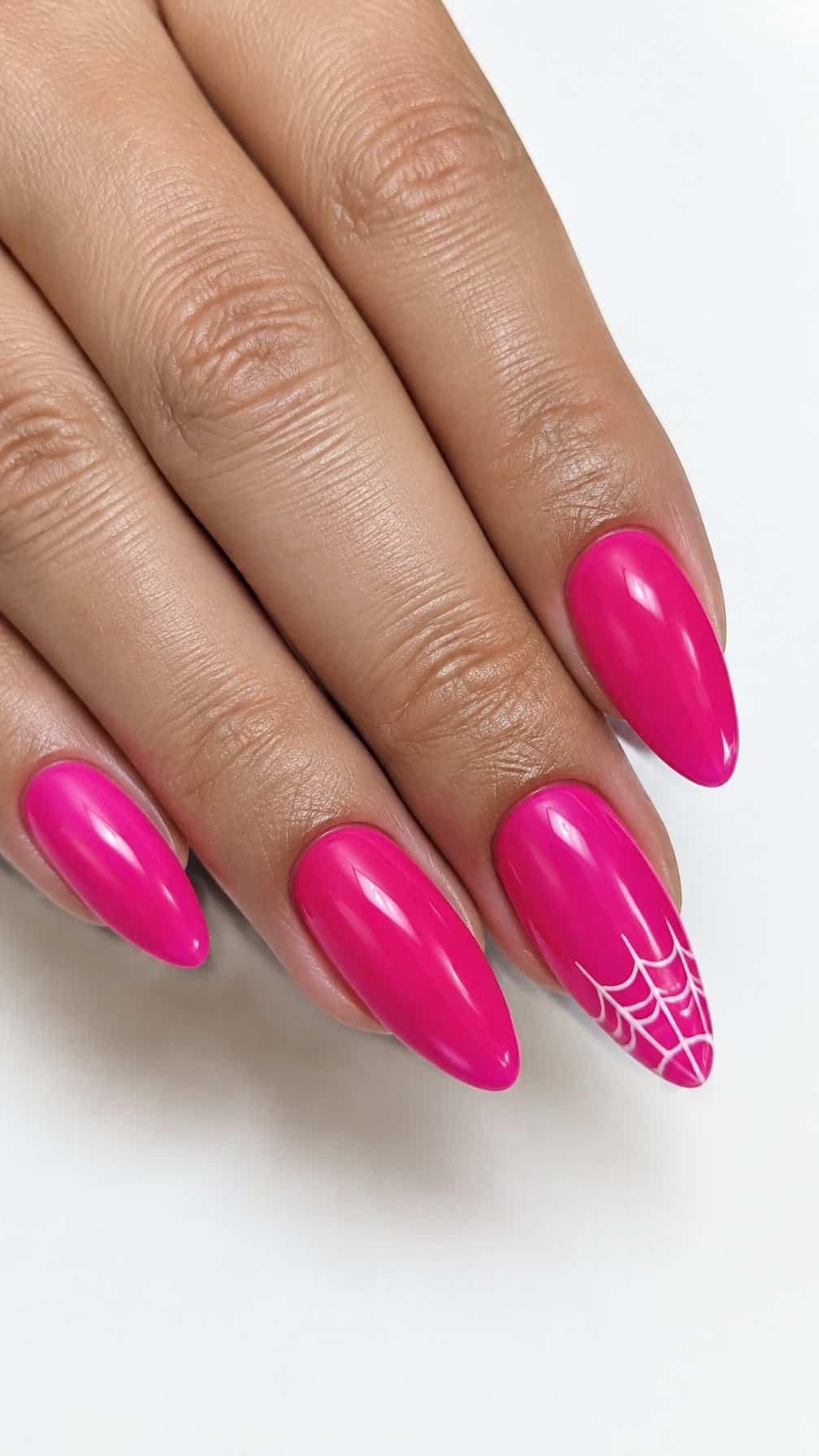 Glossy hot pink nails, some decorated with white spider web designs near the tips