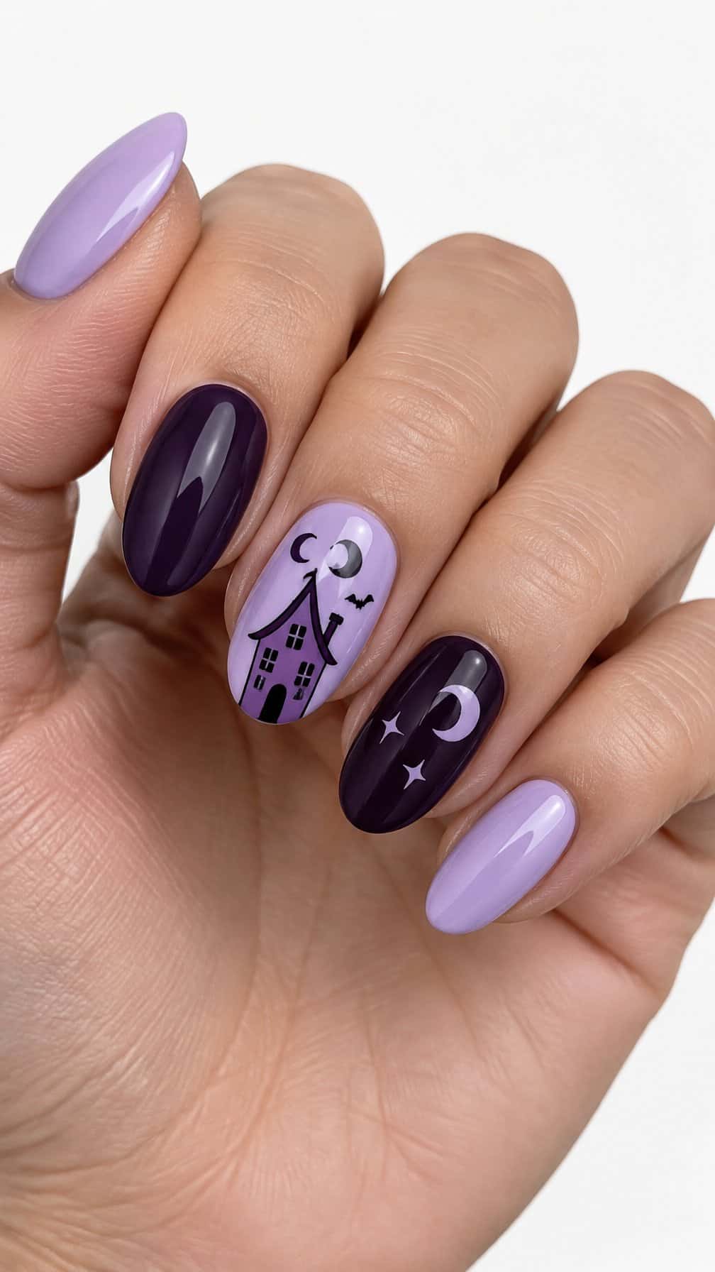 Glossy purple Halloween-themed gel nails featuring a small haunted house design