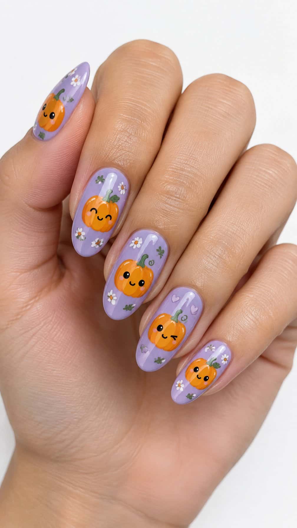 Glossy lavender nails decorated with small smiling pumpkin faces