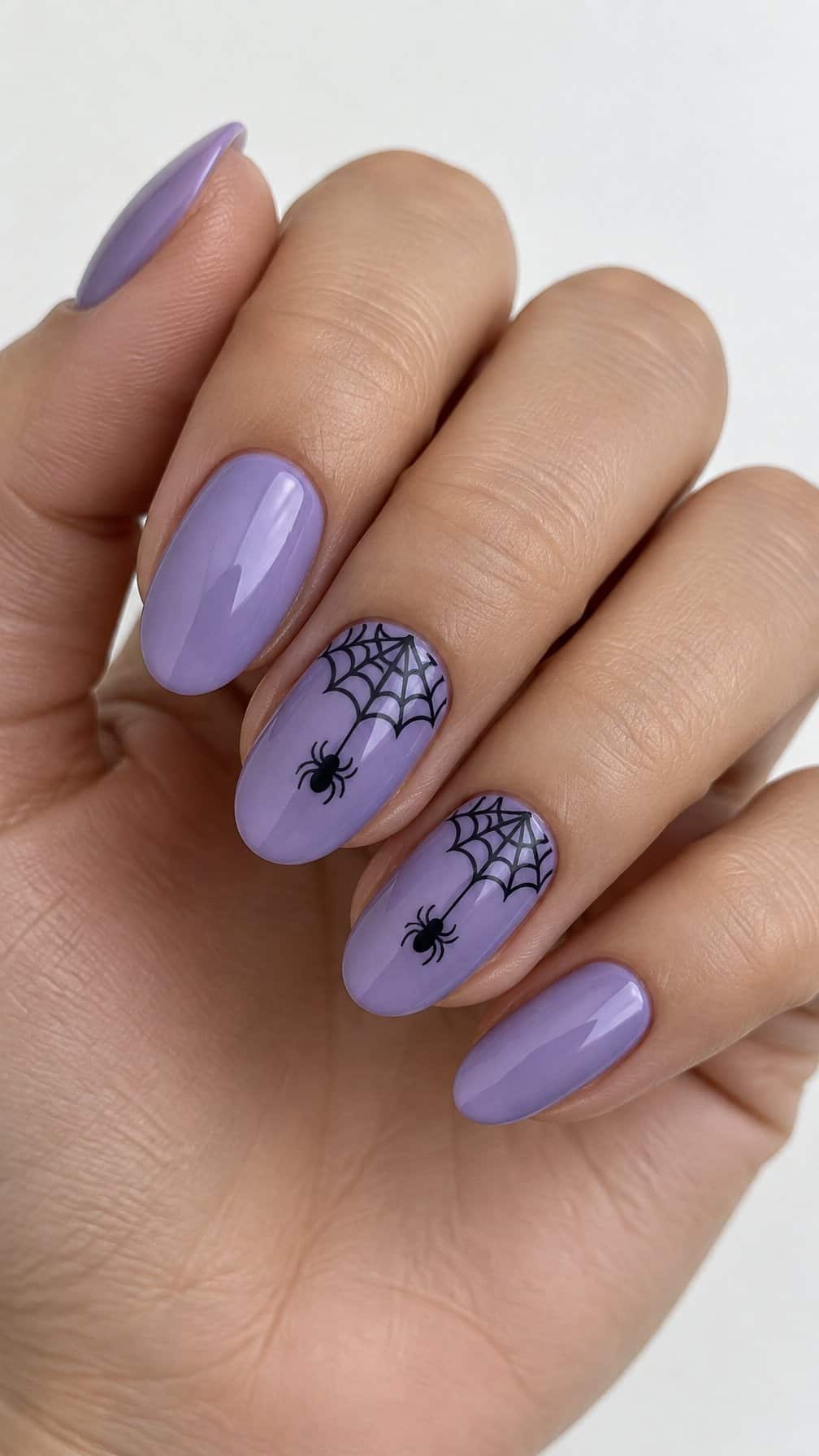 Glossy lavender nails and dark spiderweb accents on two nails