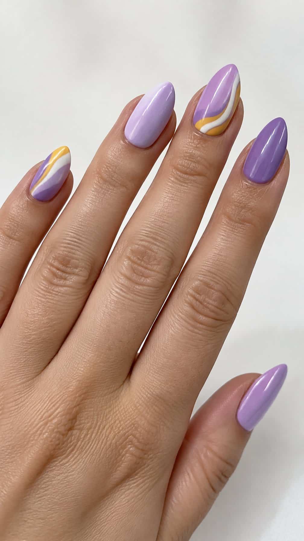 Glossy lilac, lavender, white, and yellow candy-corn swirl nails