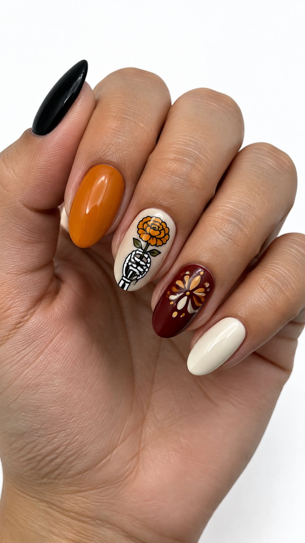 Glossy Dia de los Muertos-inspired nails featuring a skeleton hand and marigold design