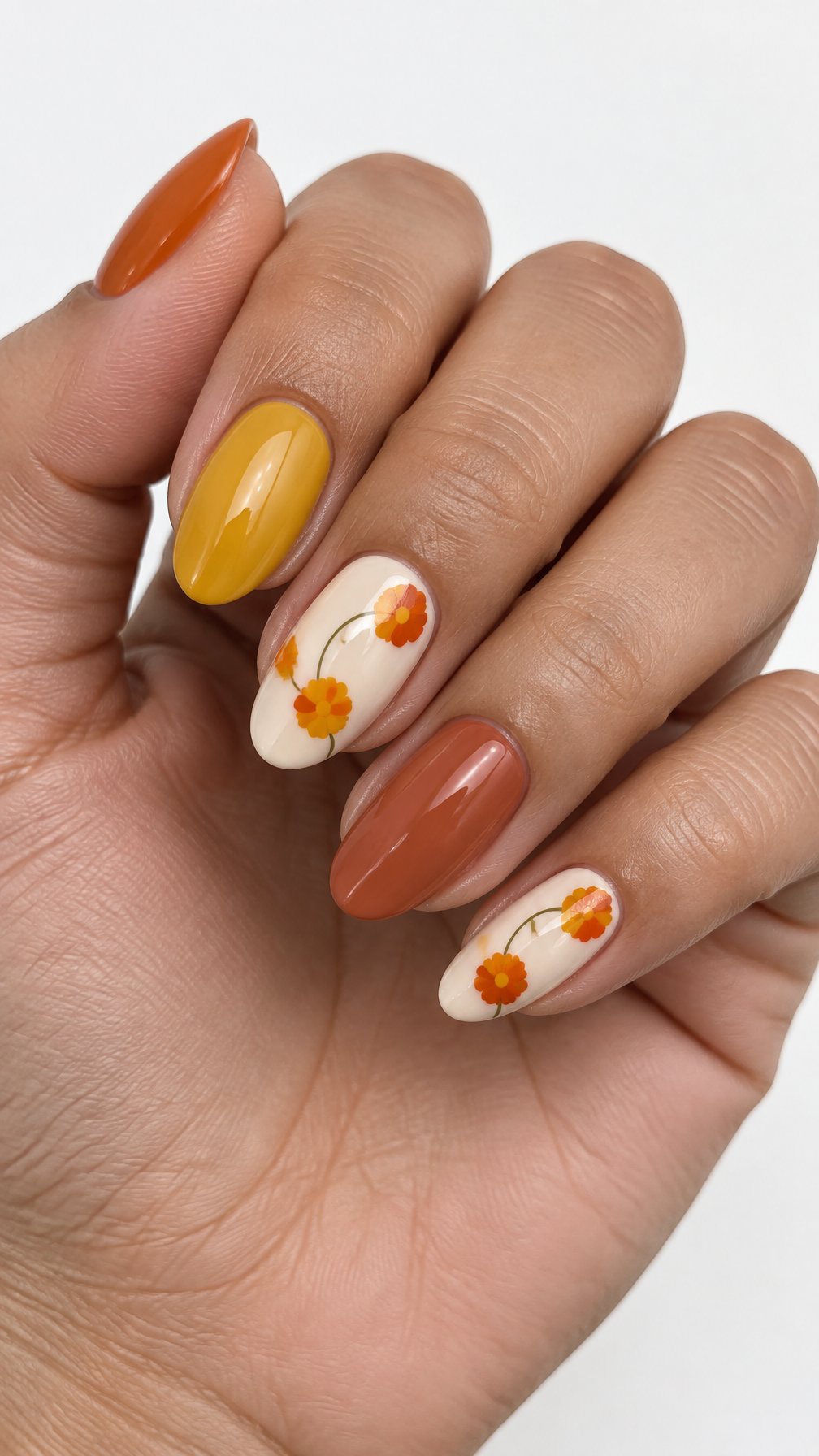 Glossy orange, yellow, and ivory marigold-themed nail art