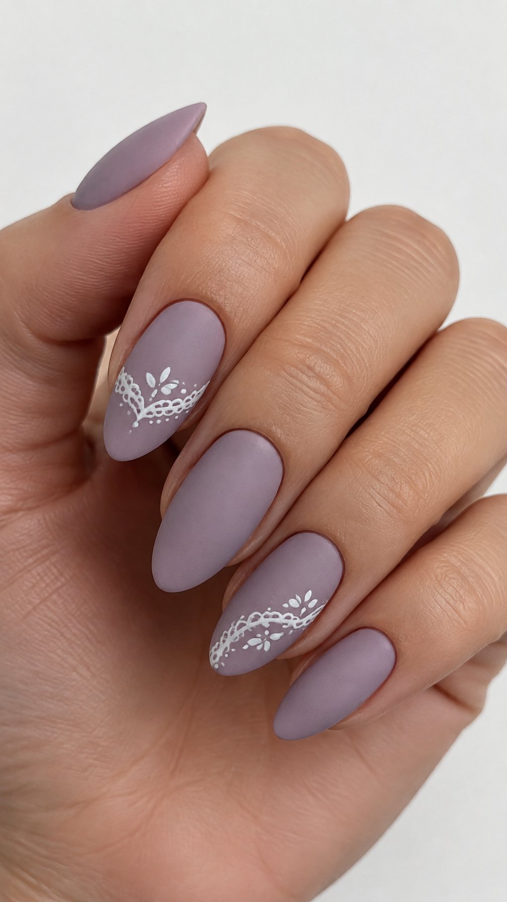 Dusty lilac nails featuring delicate white lace designs