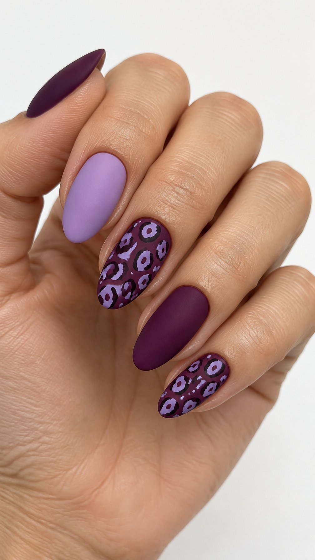 Plum and lavender gel nails featuring leopard-print accents
