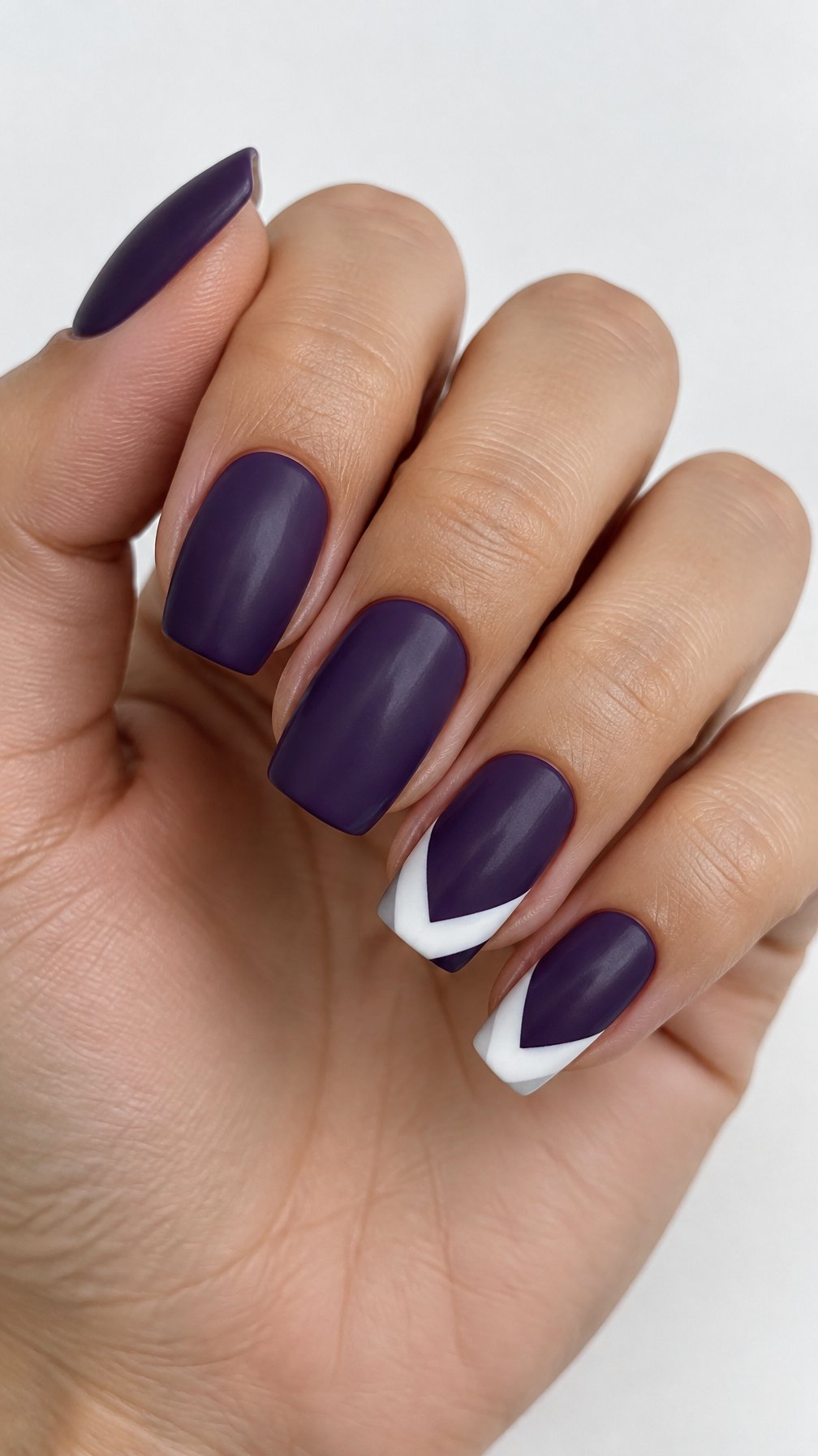 Purple gel nails, including white chevron tips on some nails