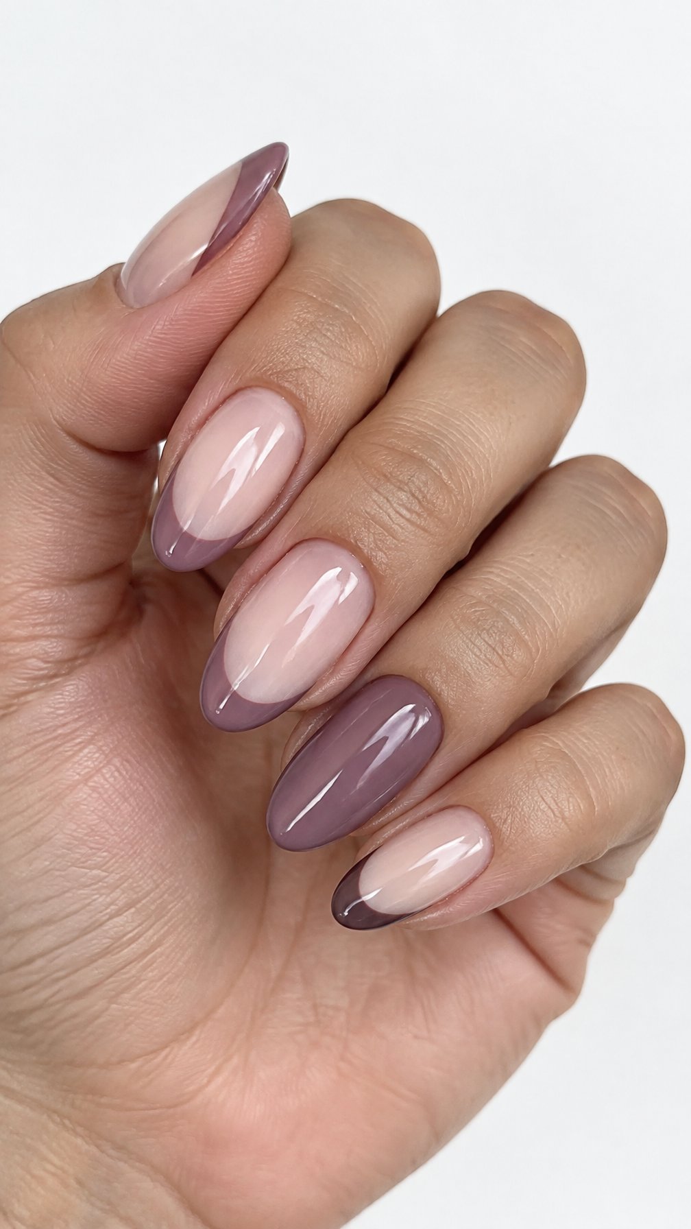Glossy mauve French-tip nails on milky nude bases