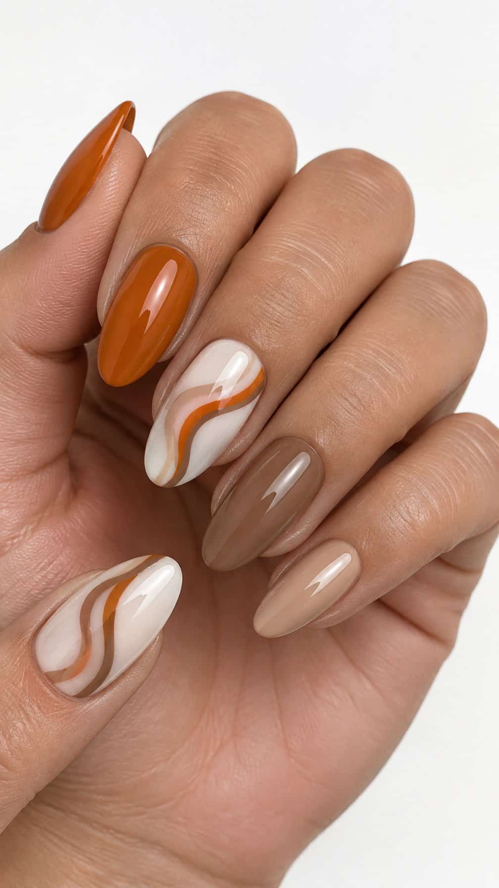 Glossy milky white, orange, and brown swirl-patterned manicure (milky white nails with pumpkin spice swirls)