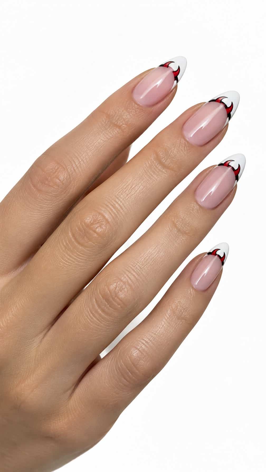 Nude French tip nails decorated with small red and black devil-horn designs