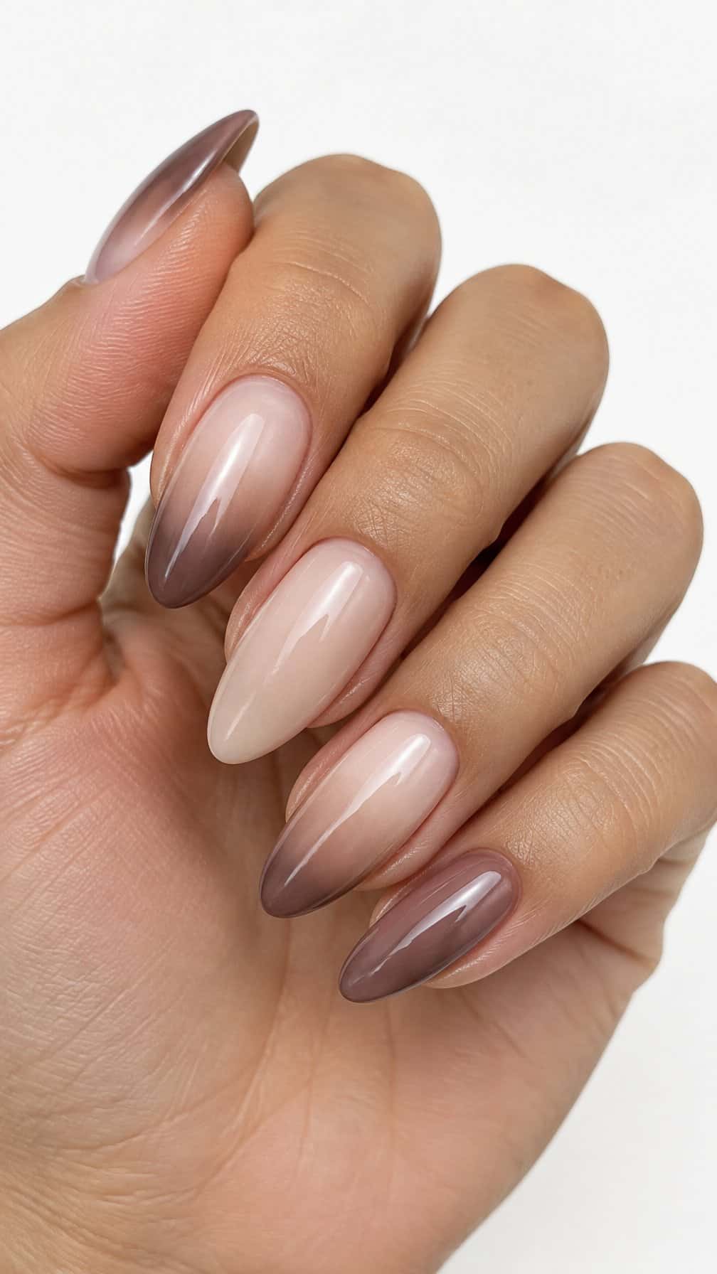 Glossy almond-shaped nails with a nude-to-mocha ombre manicure