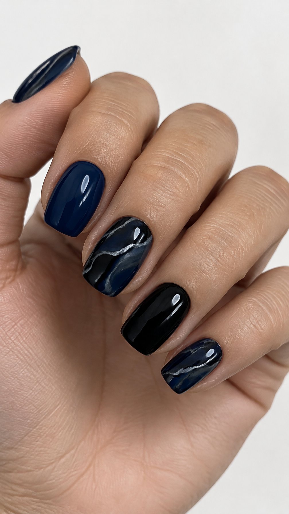 Glossy navy, black, and silver-veined marble gel nails