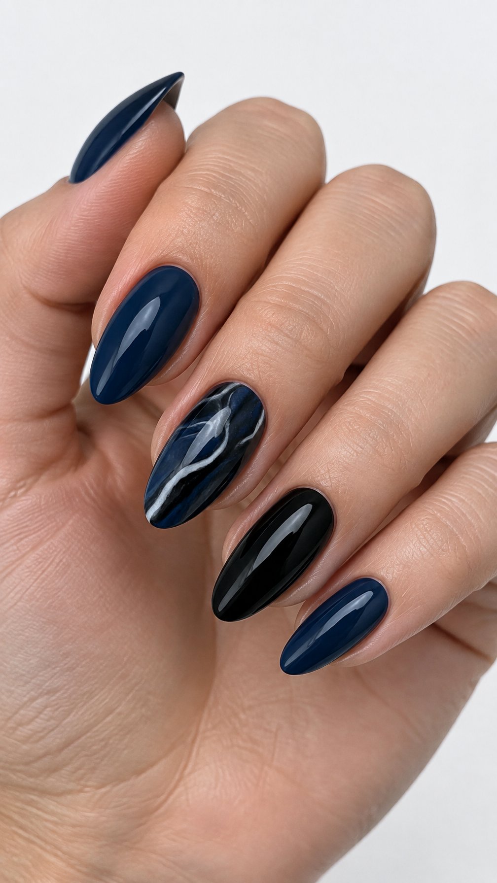 Glossy navy, black, and marble-patterned manicured nails