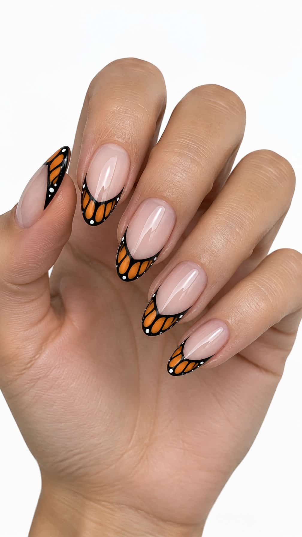 Almond-shaped nails with orange and black butterfly-patterned French tips