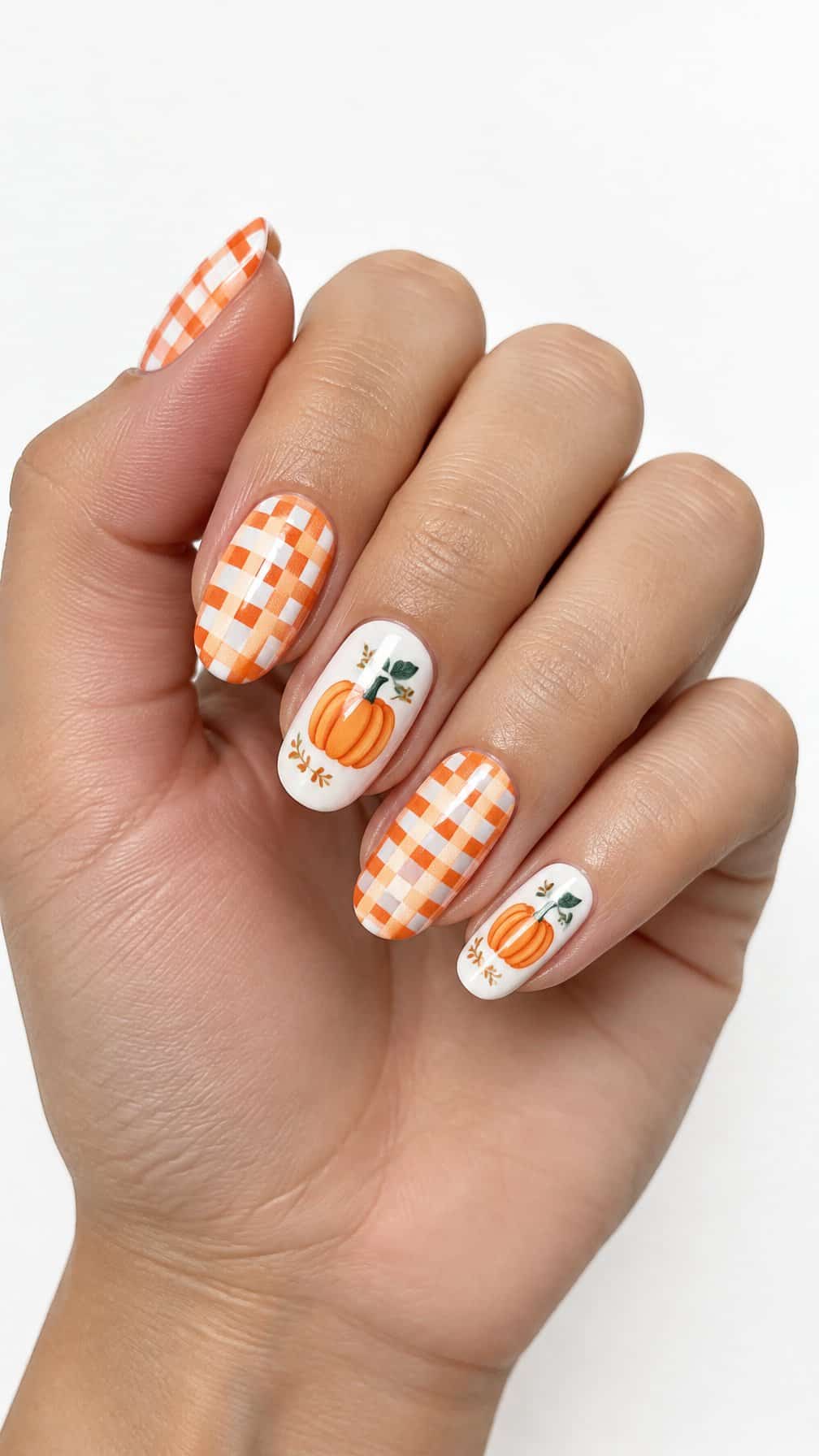 Orange and white gingham nails and small pumpkin designs