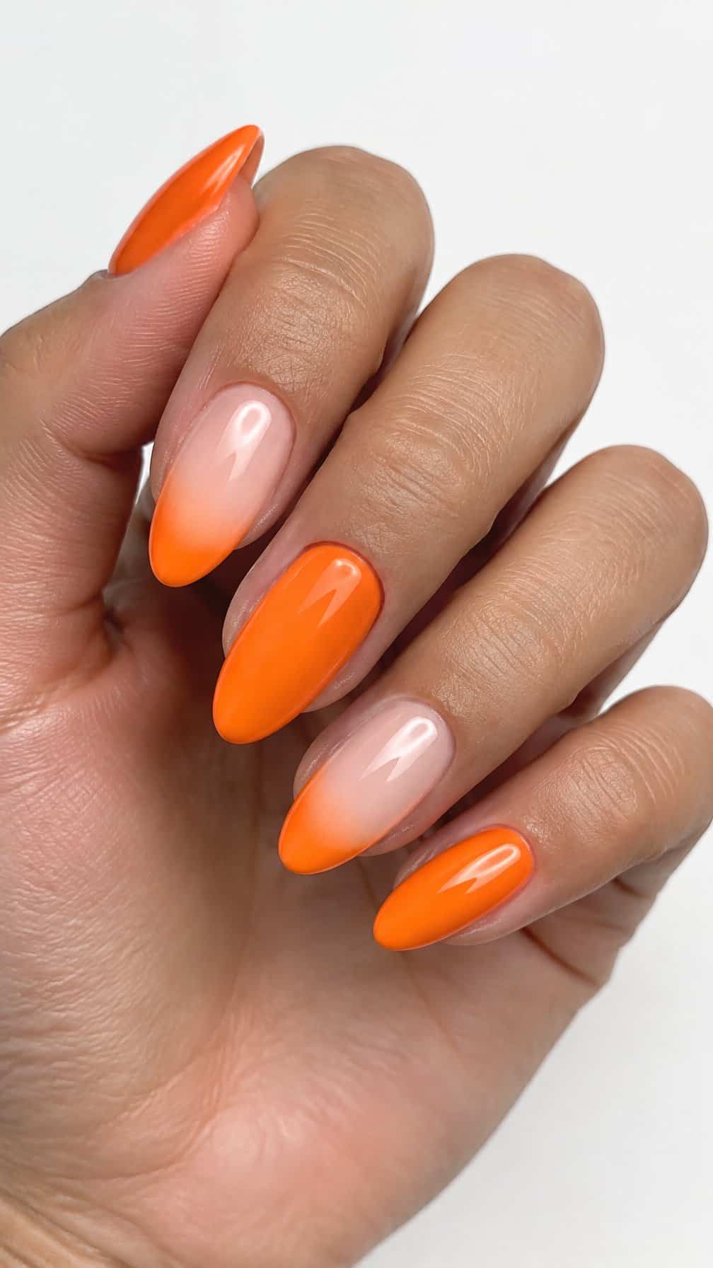 Glossy orange-tipped manicured nails