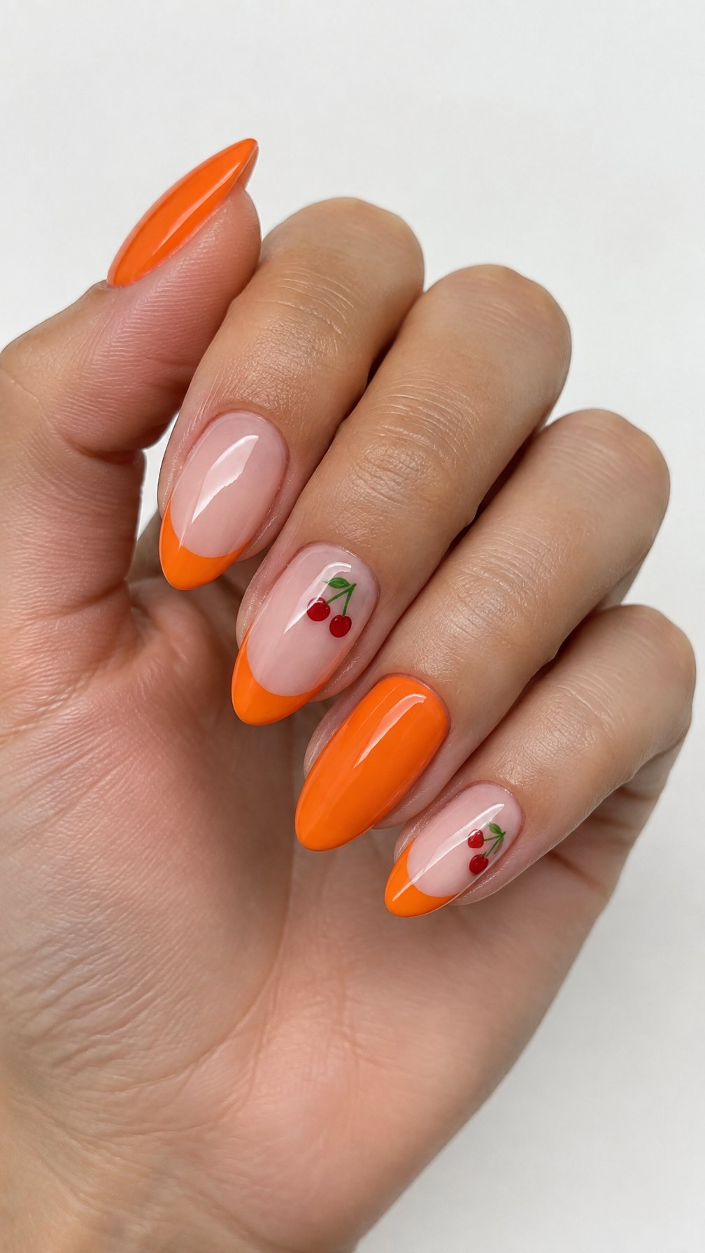 Glossy orange French-tip nails and small cherry designs