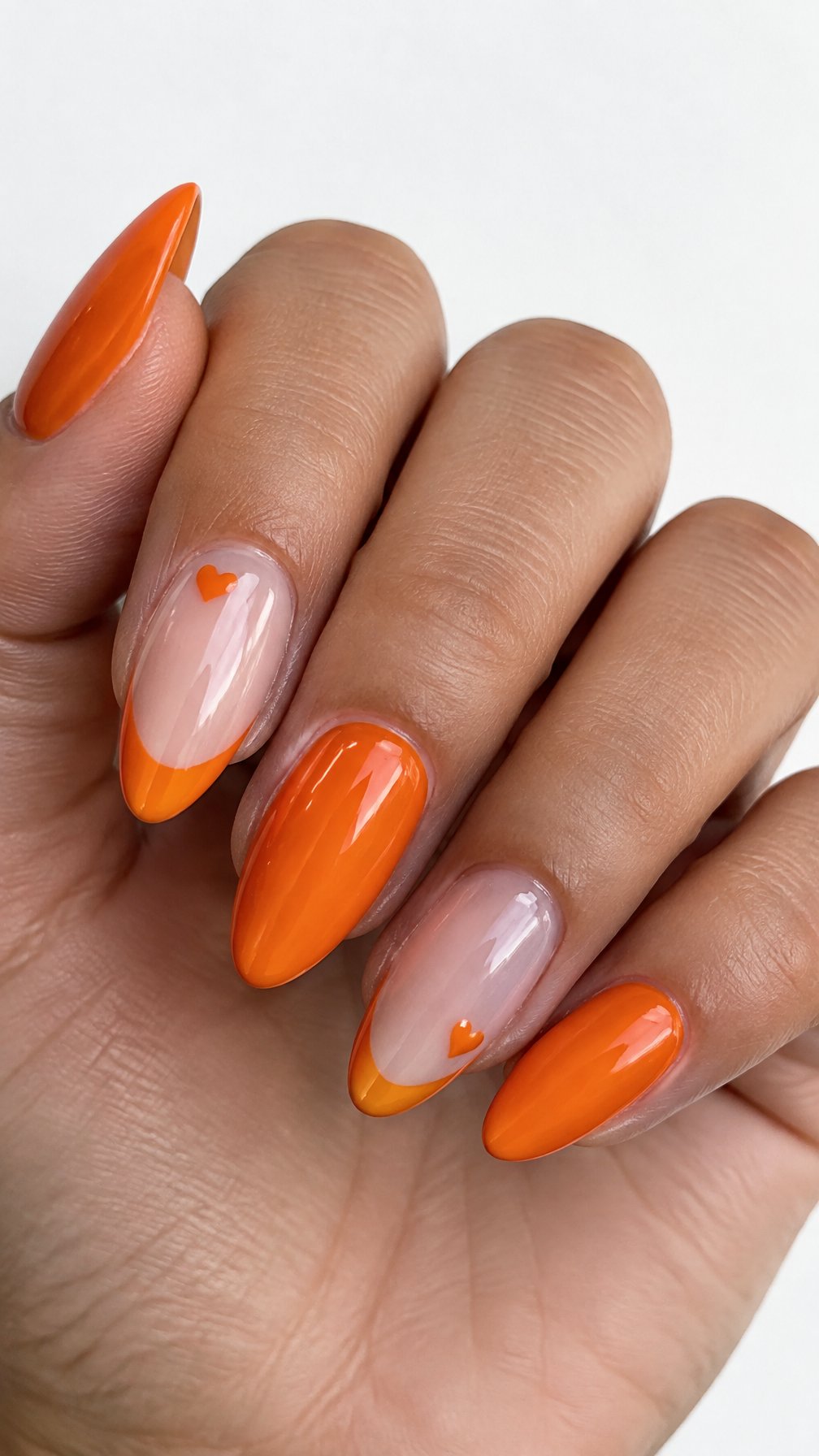 Glossy orange French-tip nails and small orange hearts