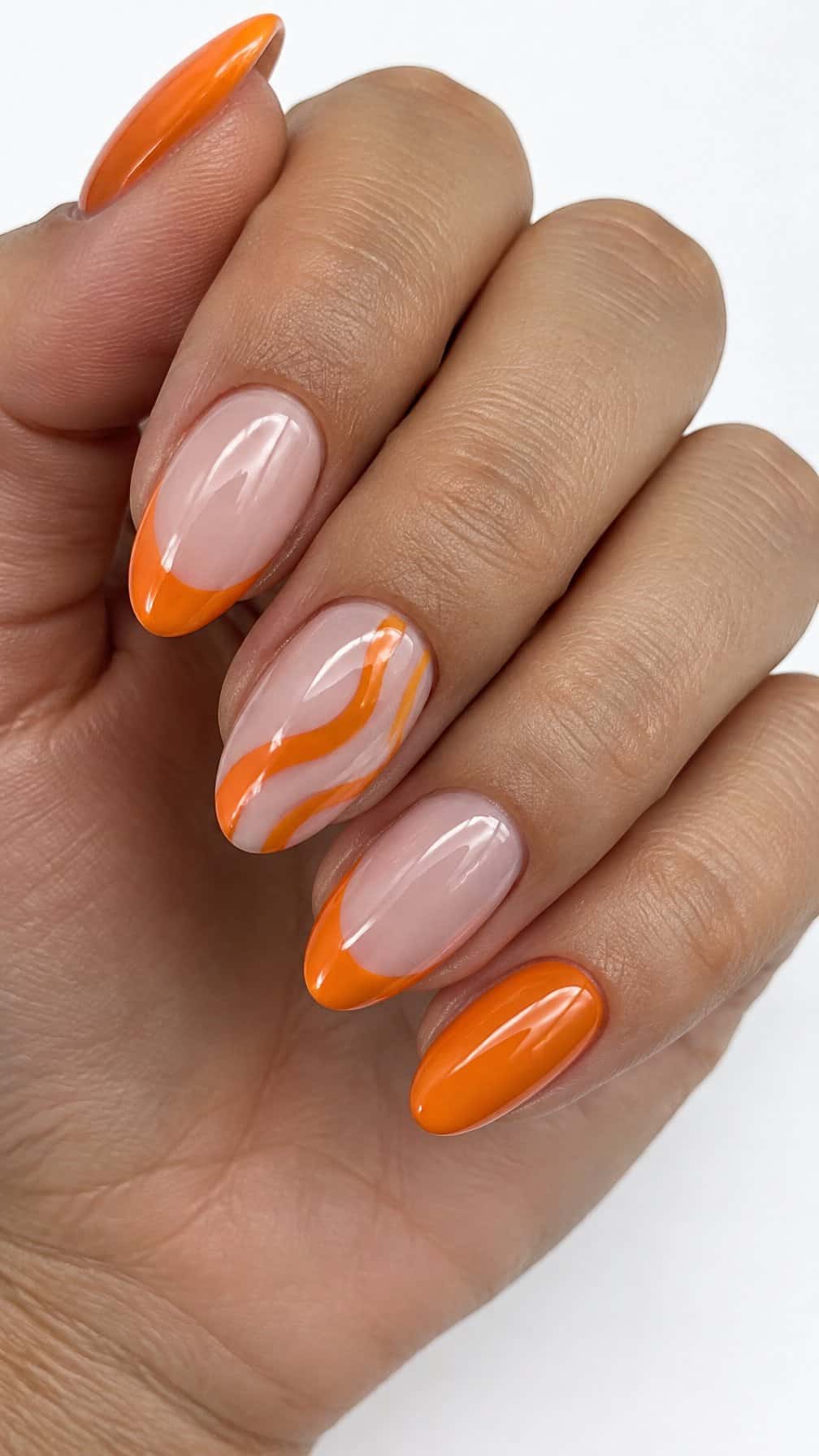Glossy orange French-tip and wavy negative-space nail designs