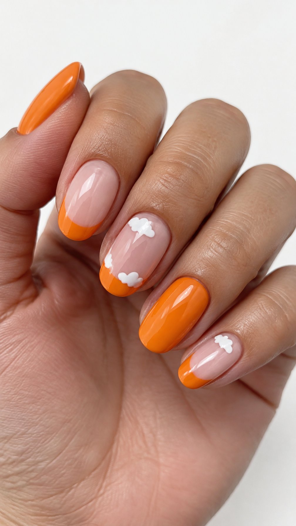 Glossy orange French tip nails and small white cloud designs