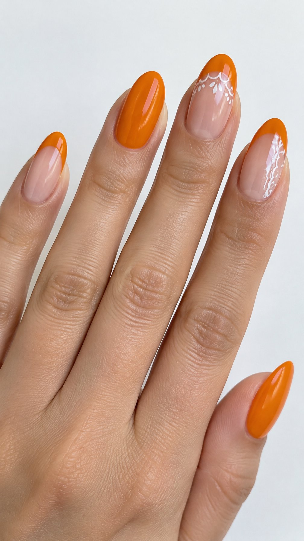 Glossy orange French tip nails and white lace accents