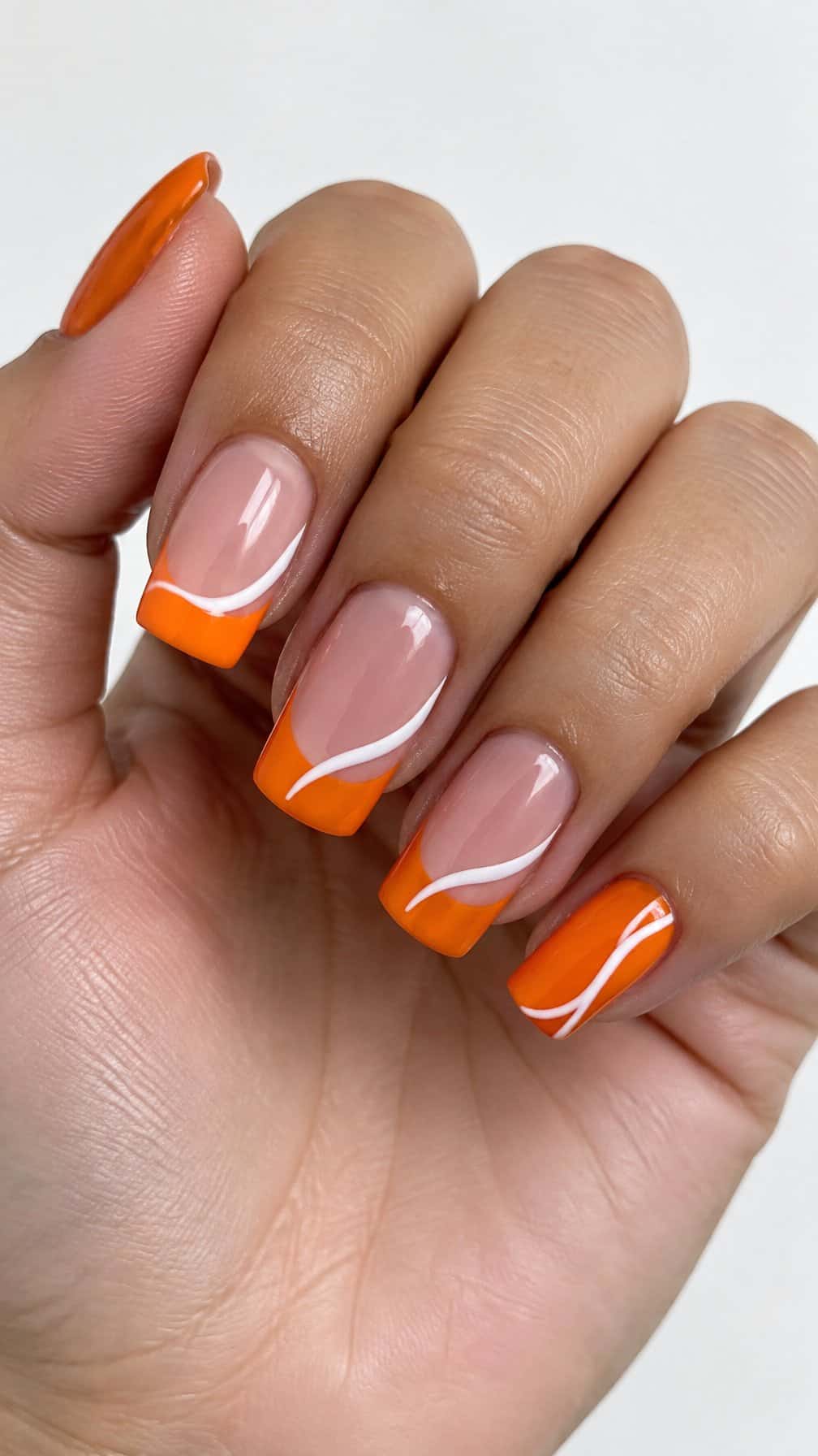 Orange French tip nails and white swirl designs