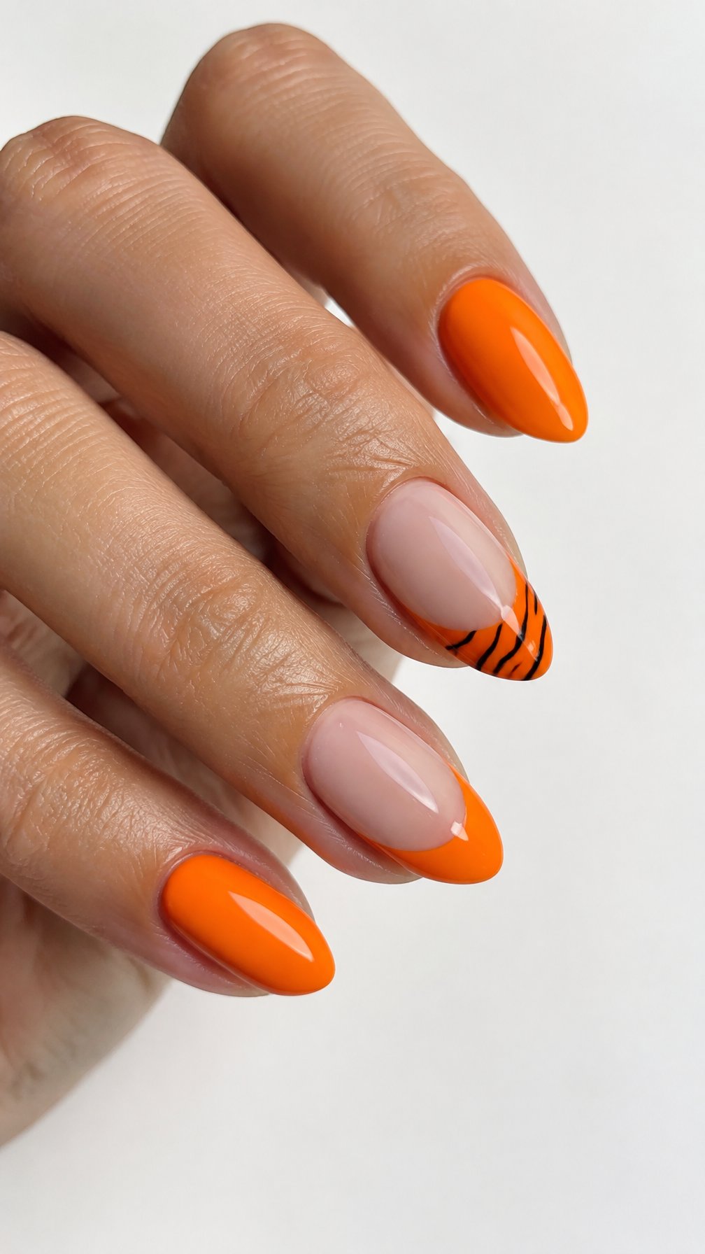 Glossy orange French-tip nails and black zebra stripe accents