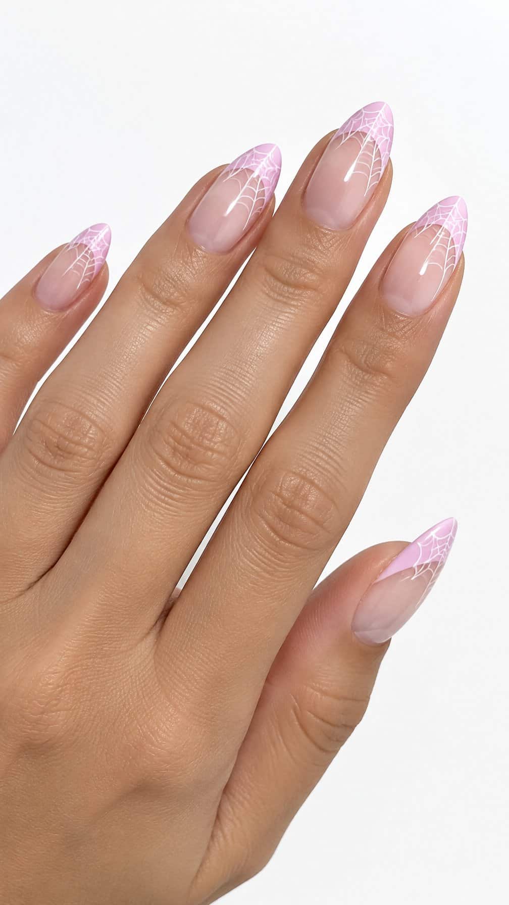 Pastel pink French tip nails decorated with delicate white spider web designs