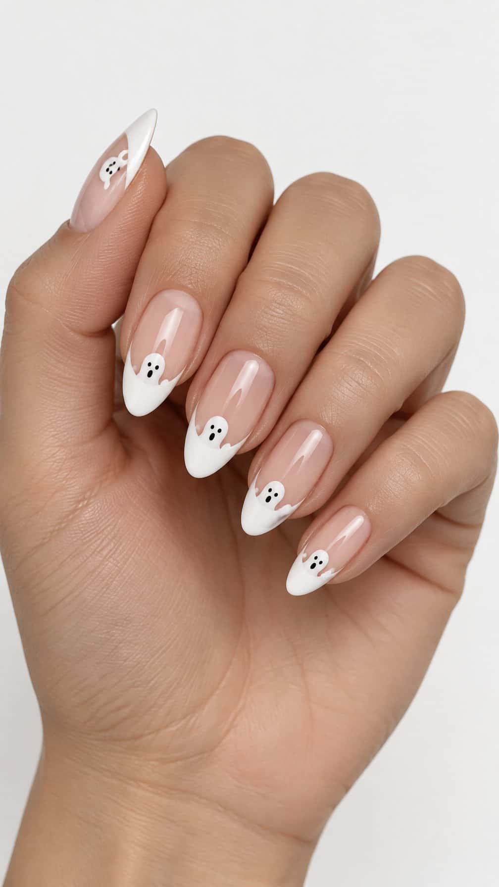 Glossy nude nails, white French tips, and tiny ghost designs