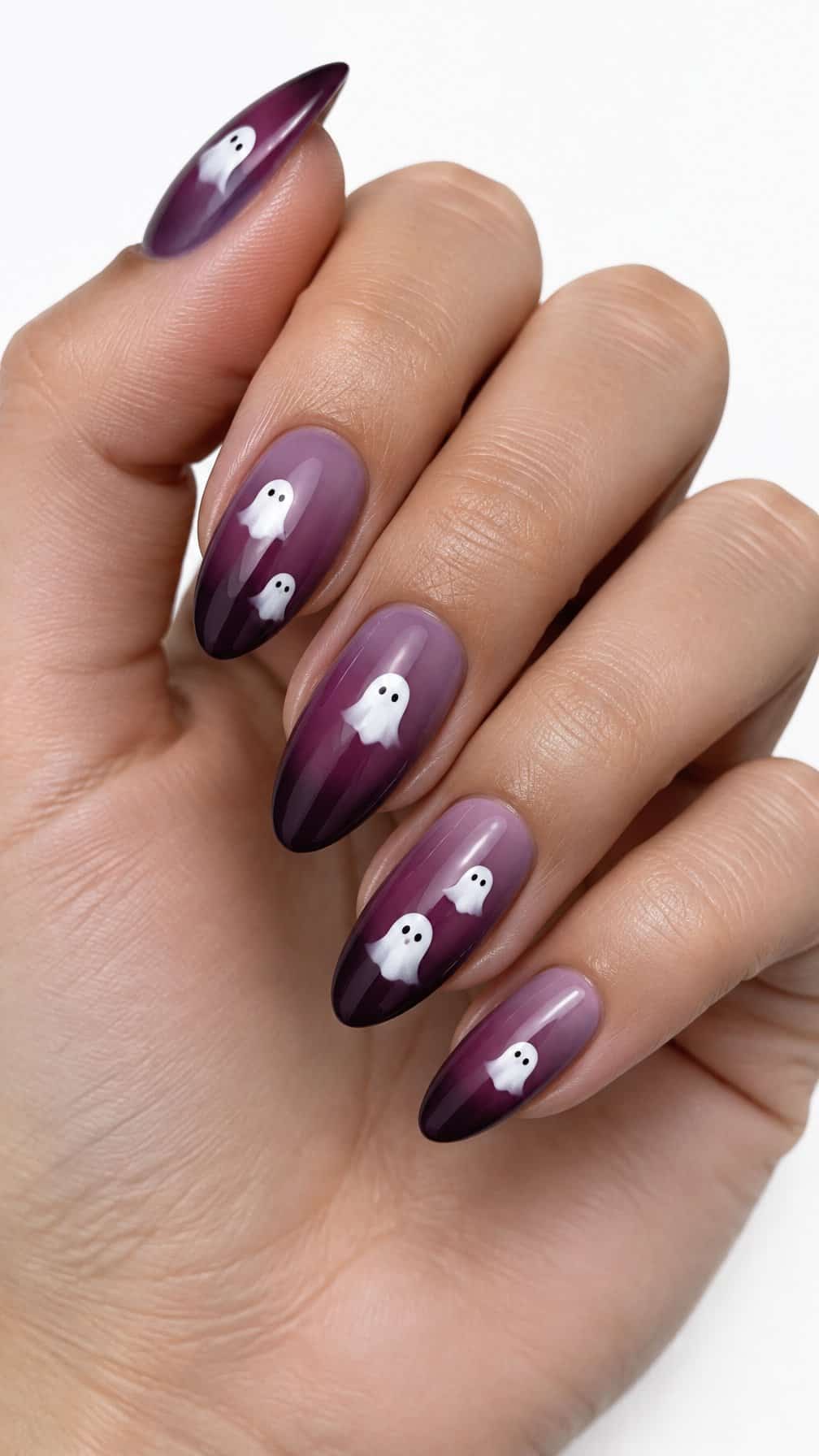Glossy plum gradient nails decorated with tiny white ghost designs