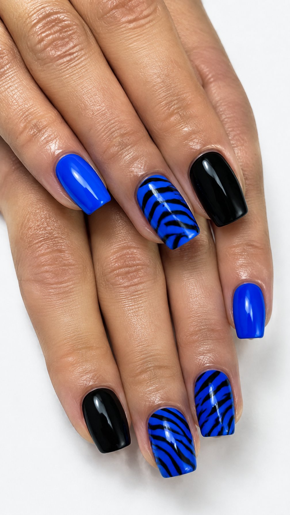 Glossy electric blue, black, and zebra-patterned nails
