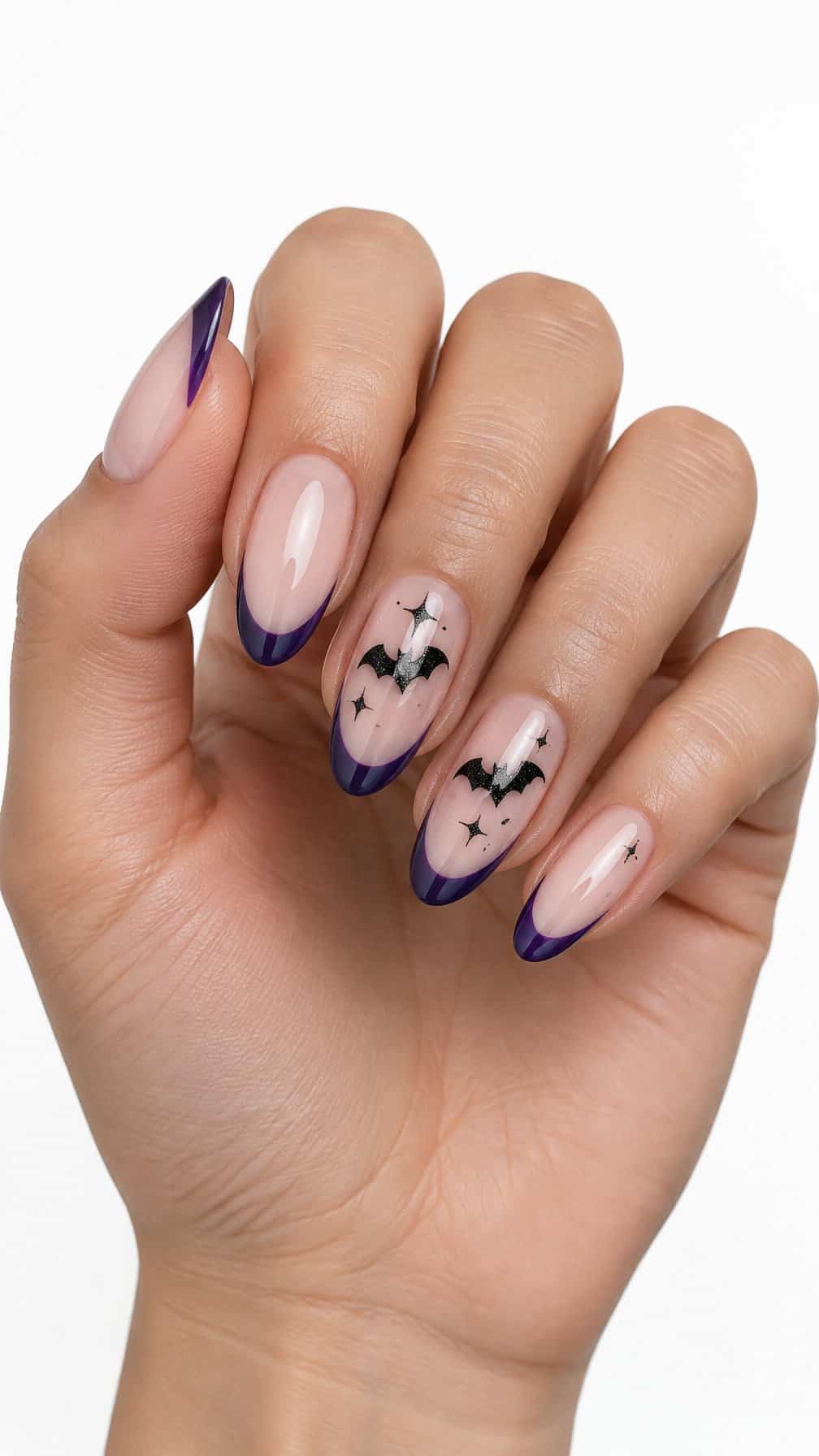 Glossy purple French-tip nails decorated with small black glitter bats