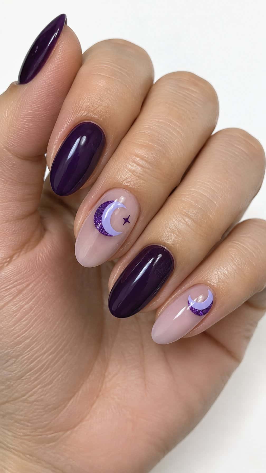 Glossy purple manicure featuring crescent moon designs and glitter accents