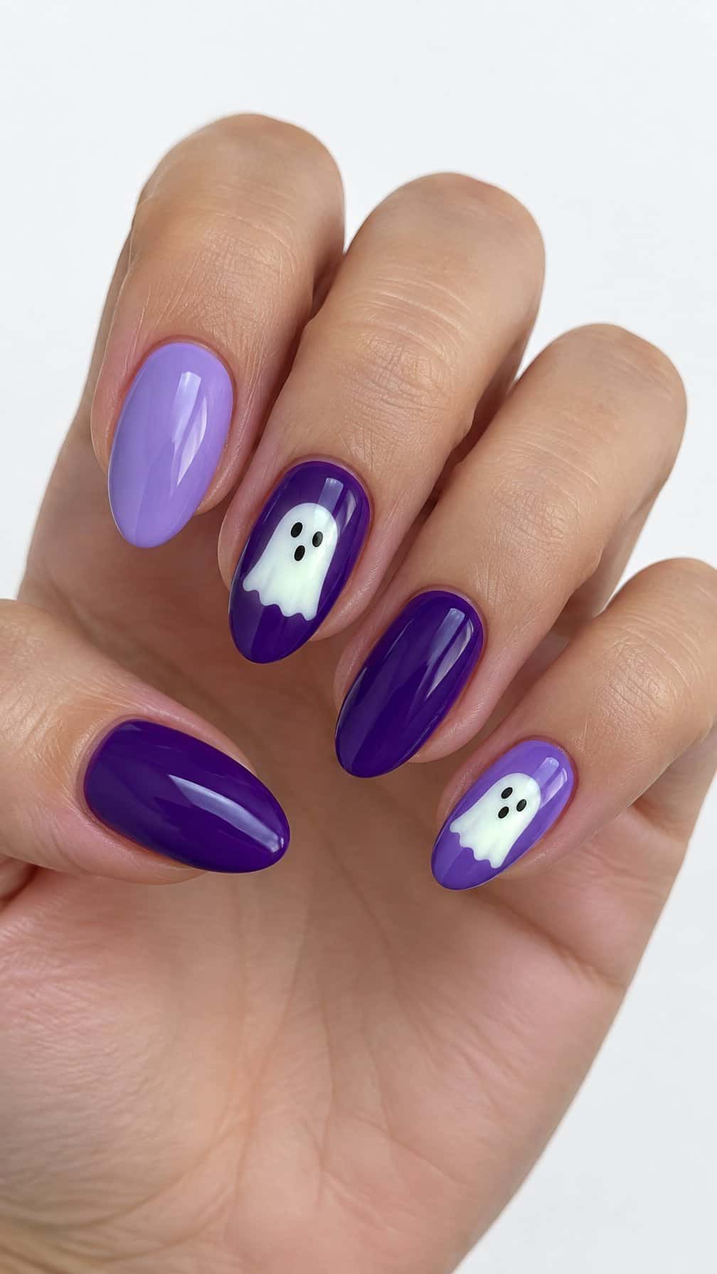 Glossy purple Halloween gel nails featuring small white ghost designs