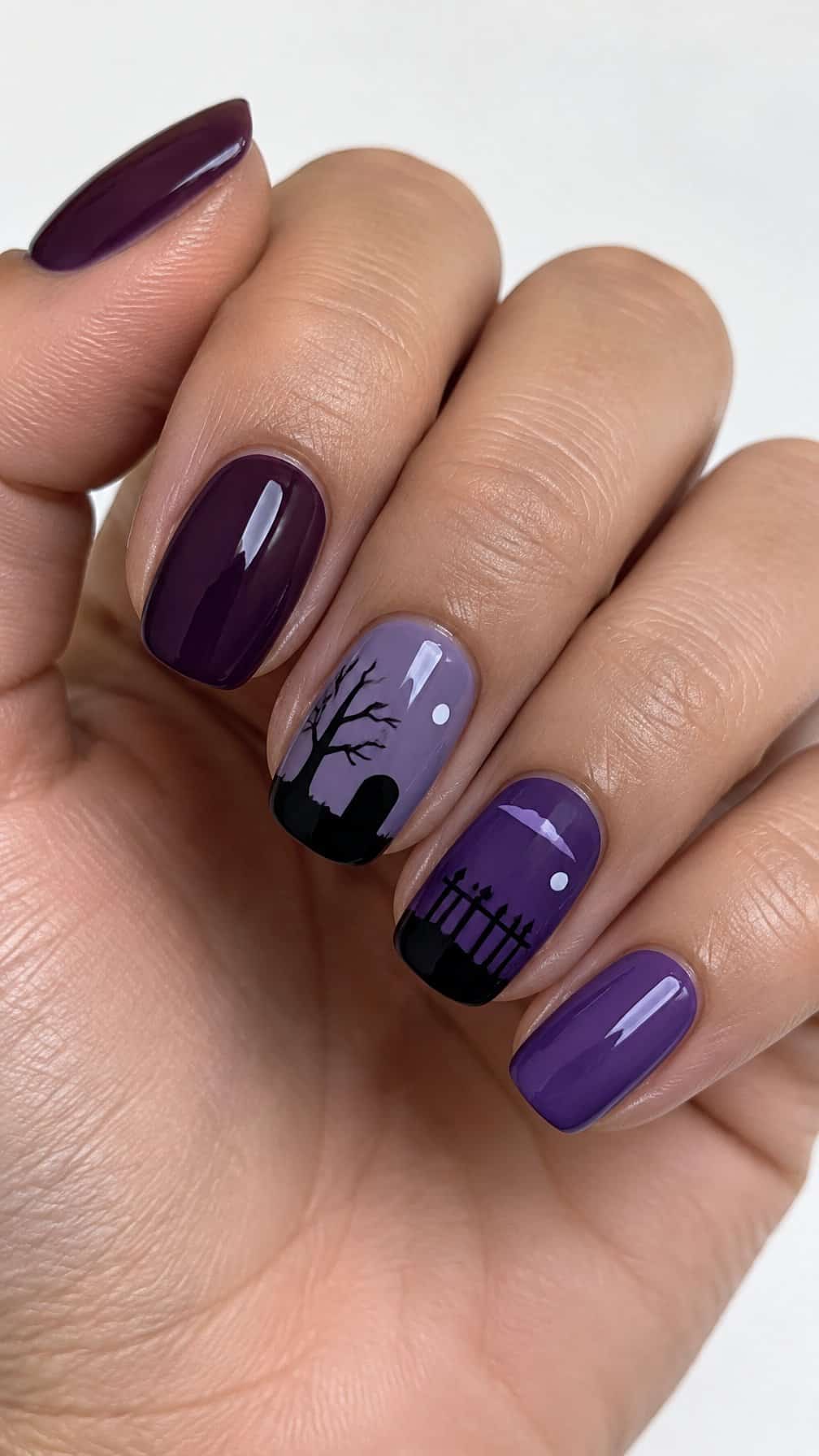 Glossy purple Halloween graveyard nail art is shown close up
