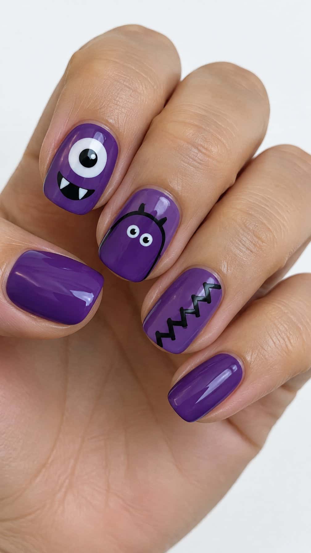 Glossy purple Halloween monster-themed nail art