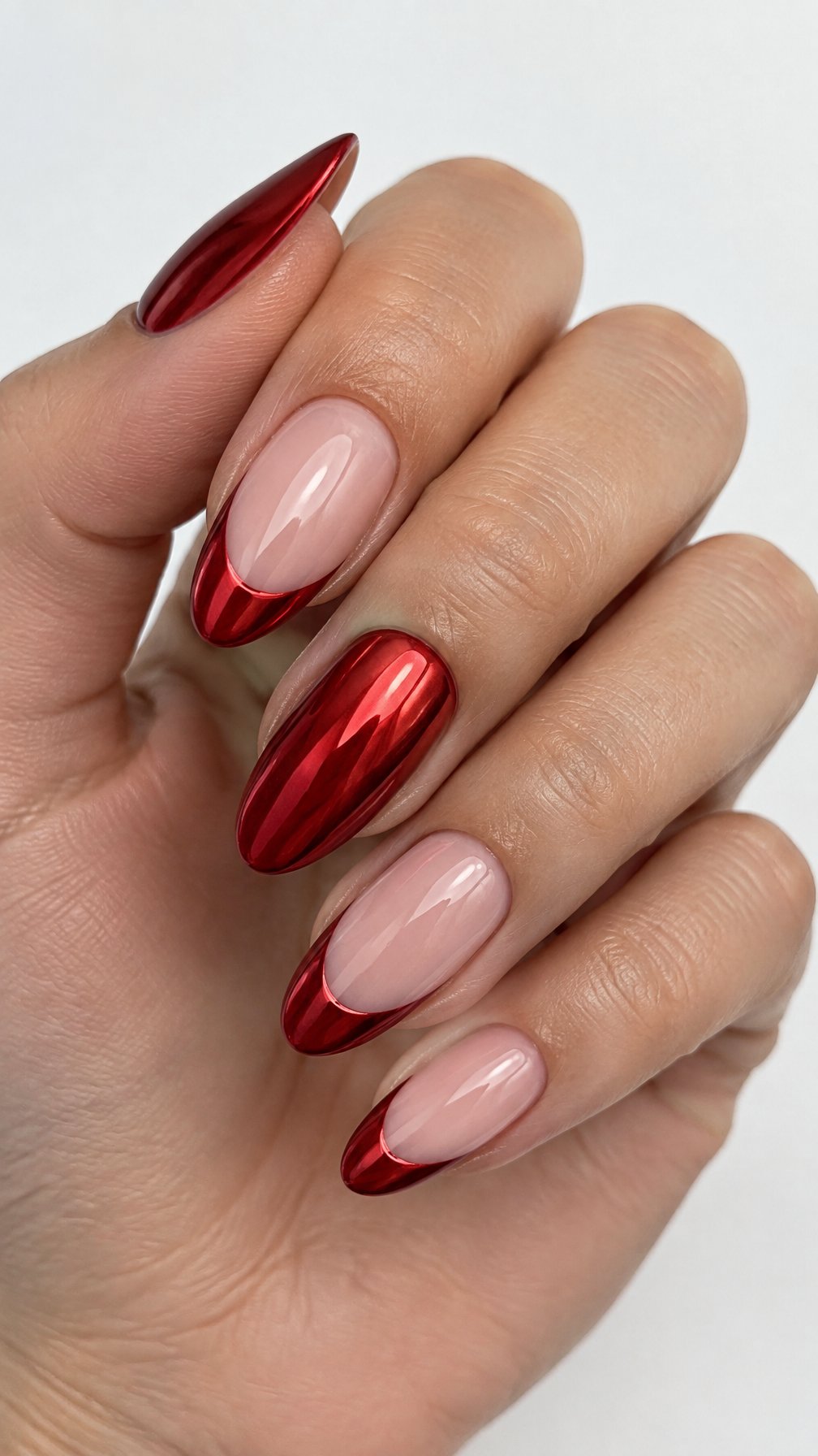 Almond-shaped nude nails featuring glossy red chrome French tips