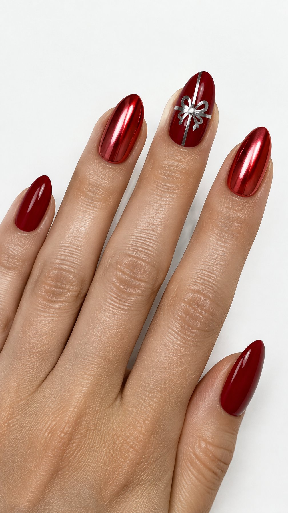 Glossy red and chrome nails, including a ribbon design on one accent nail