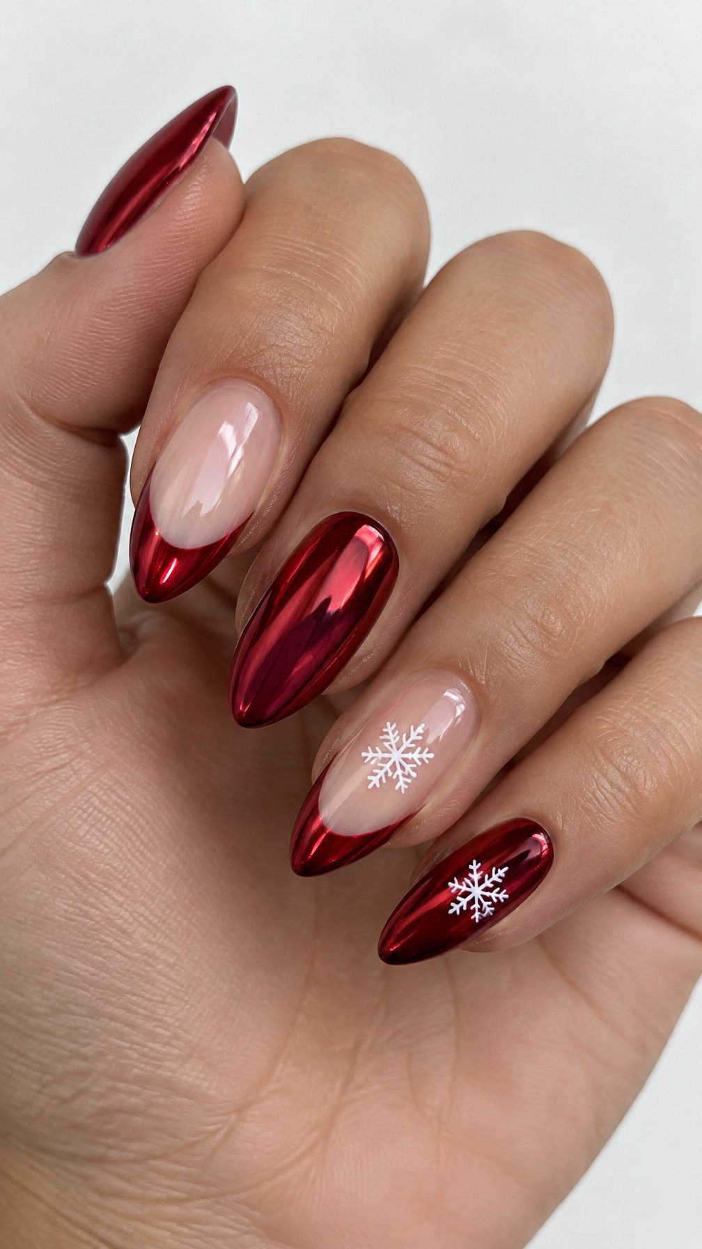 Glossy red French-tip nails and small white snowflake designs