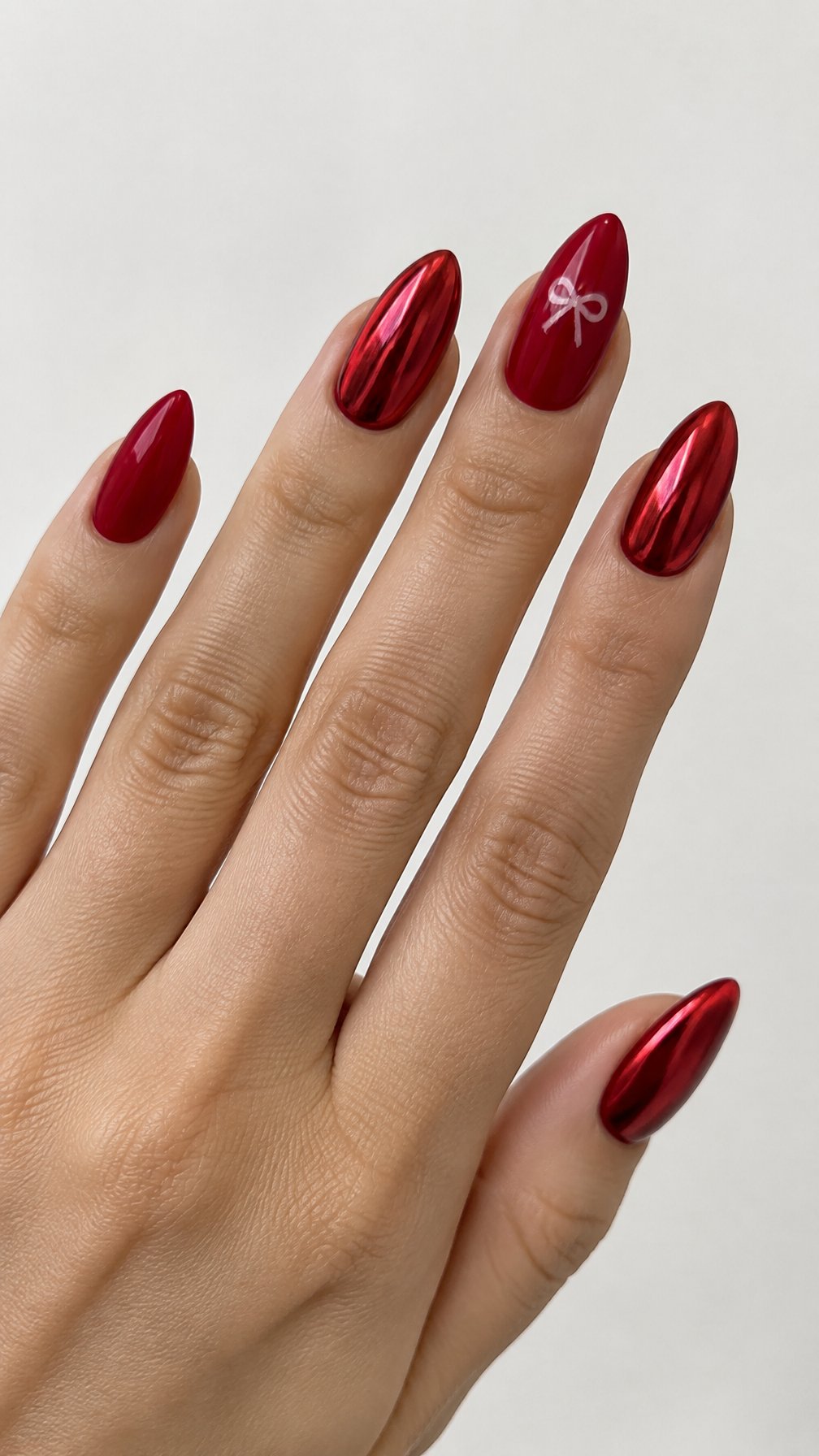 Glossy scarlet red chrome nails and tiny bow designs