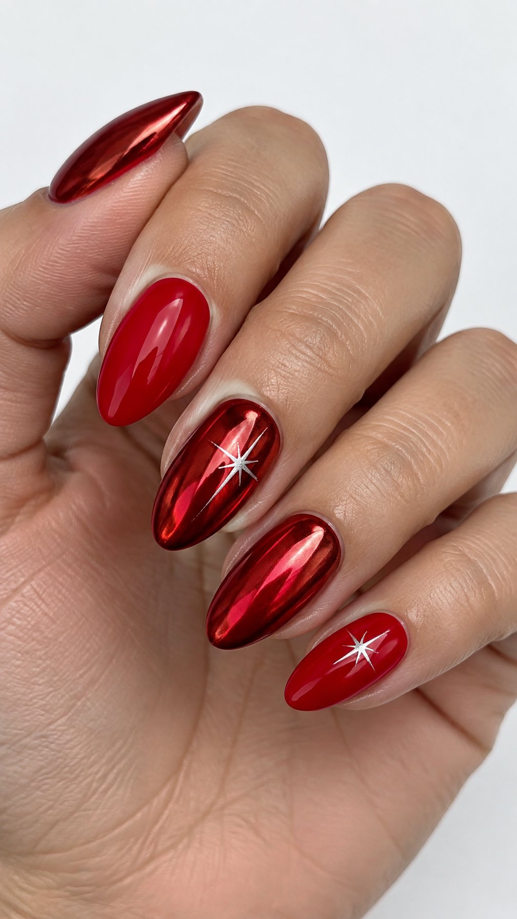 Glossy red nails, including silver starburst designs on two accent nails