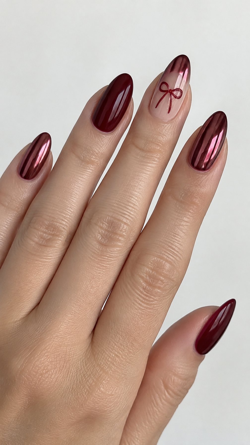 Glossy burgundy red manicure nails with small bow designs