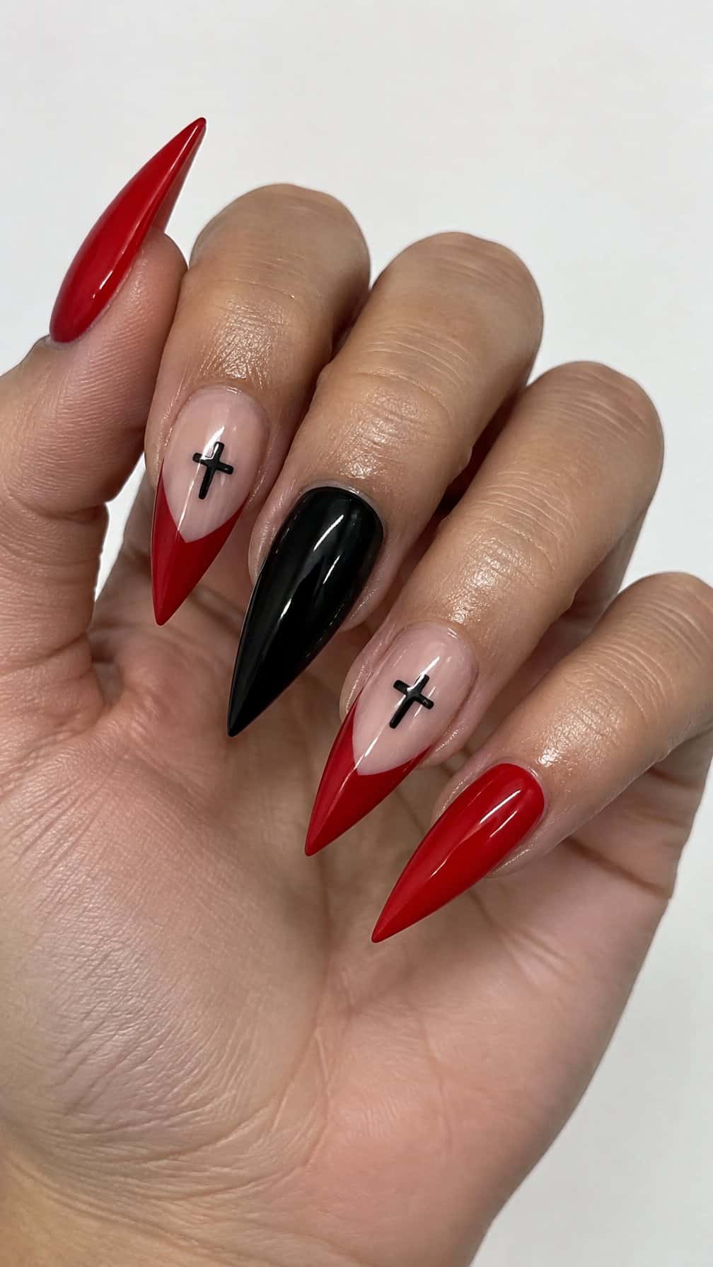 Long red and black pointed nails decorated with small black crosses