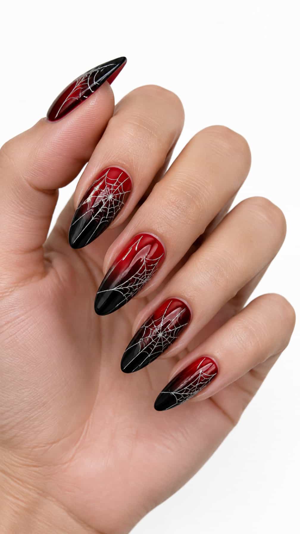 Glossy red-to-black gradient nails decorated with delicate spider web designs
