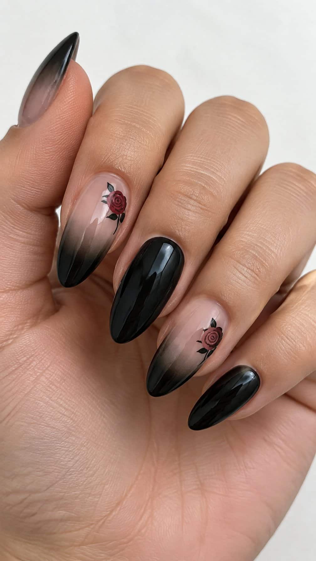 Glossy black ombre French-tip nails and small rose designs