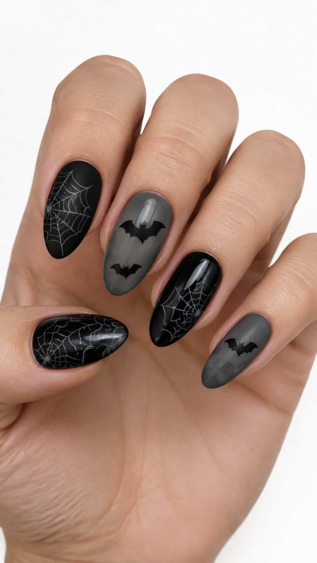 Black spider web and bat designs on neatly manicured nails