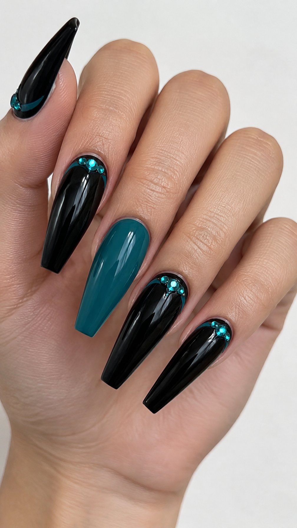 Long glossy black and teal coffin-shaped nails featuring teal accents near the cuticles