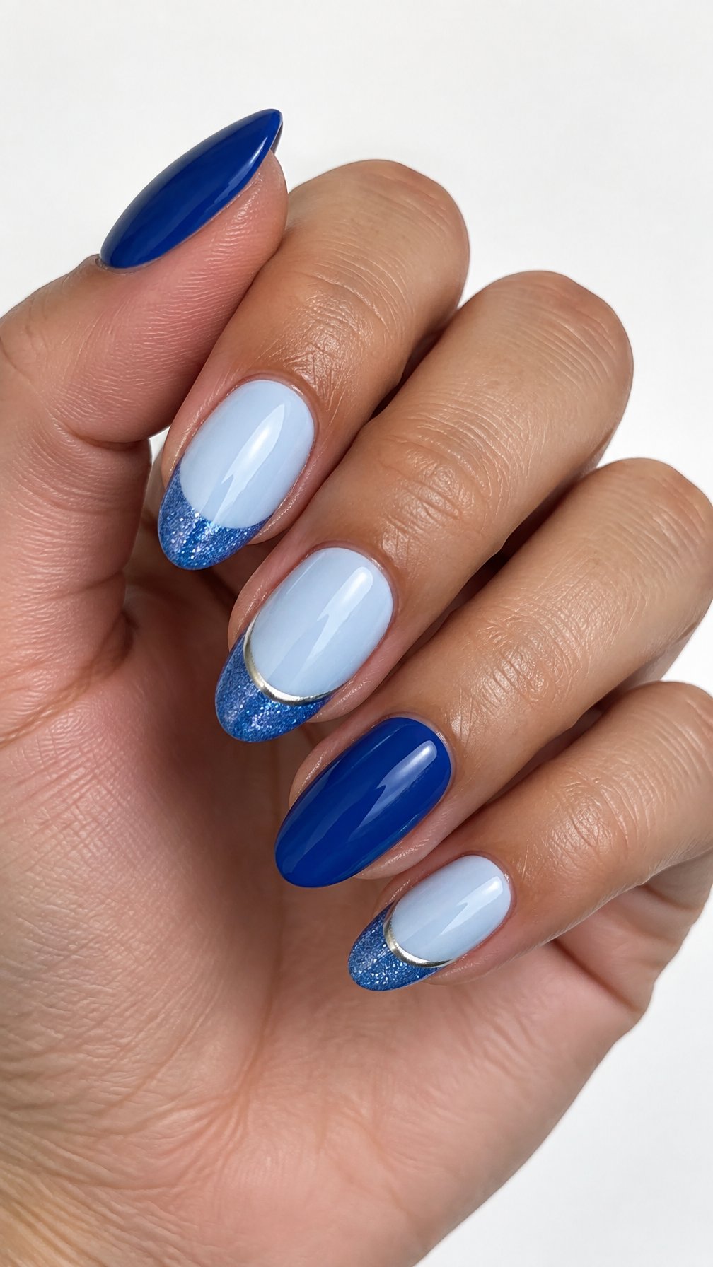 Glossy blue and silver glitter-tip manicured nails