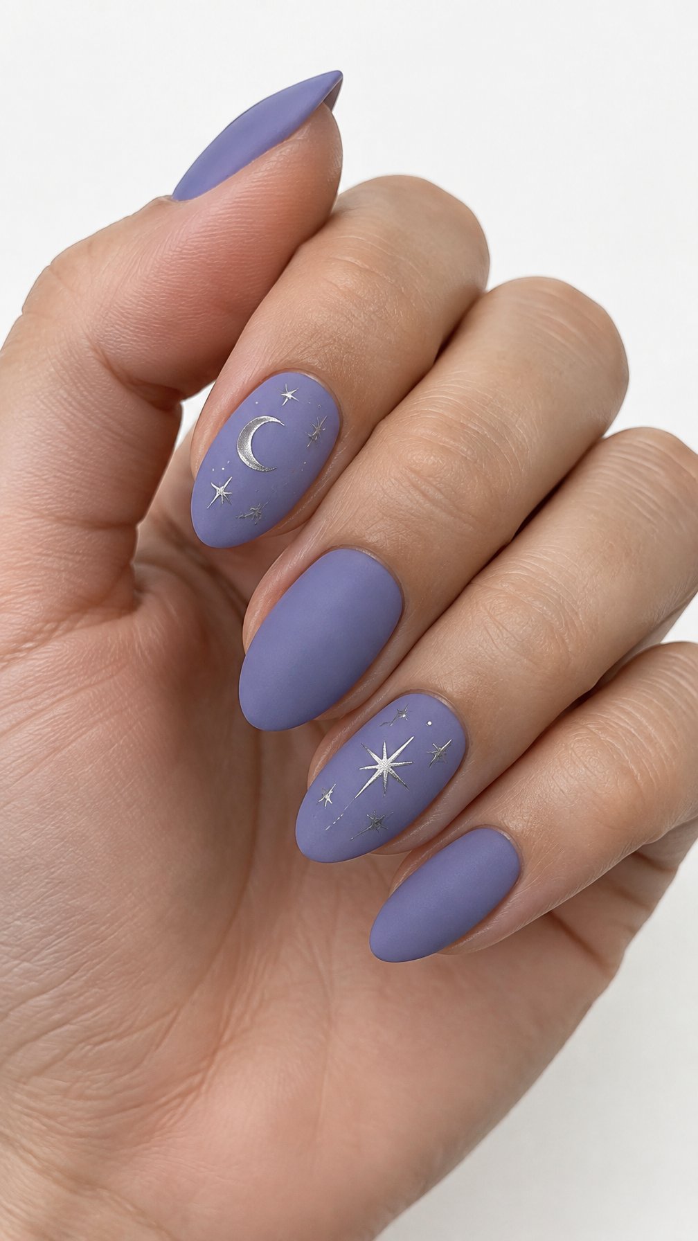Matte periwinkle nails decorated with small silver stars and crescent moons